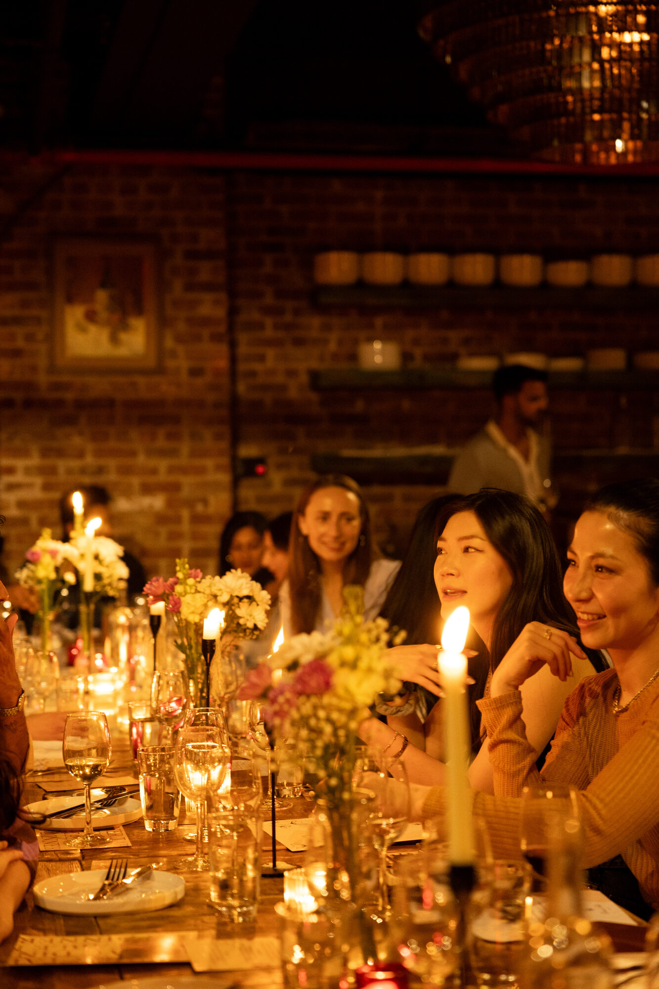 Guests talking across a candlelit table